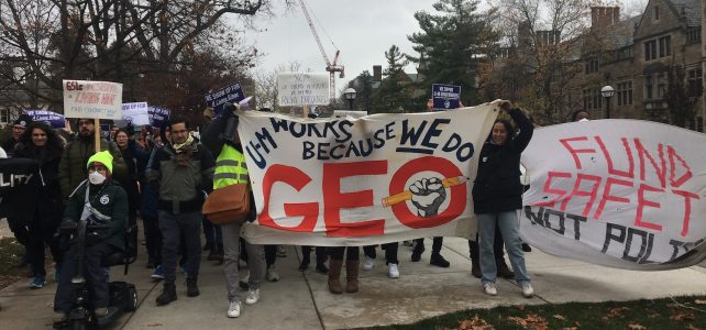 several people holding banners in support of GEO and a non-police response marching together