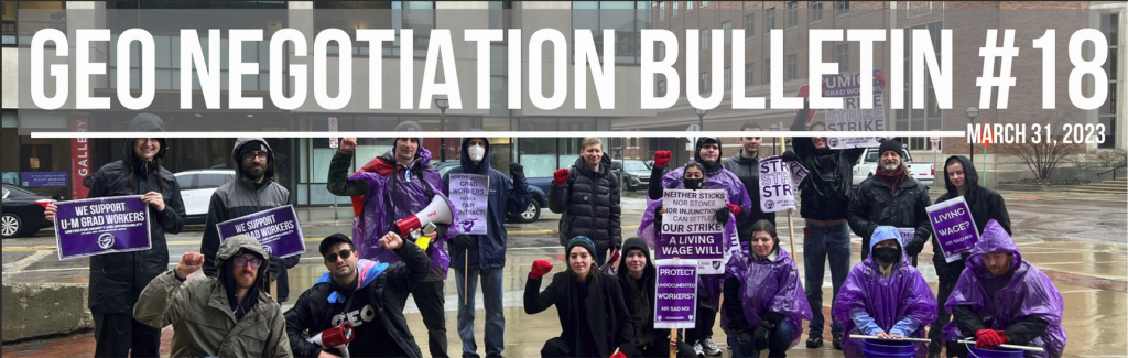 A group of people wearing rain gear holding their fists up and picket signs