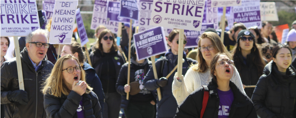 A group of people holding picket signs and chanting