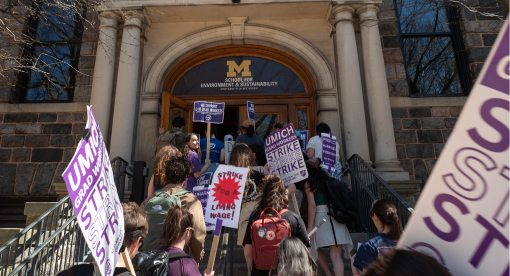 A group of picketers filling the stairs up to the School for Environmental Sustainability. 