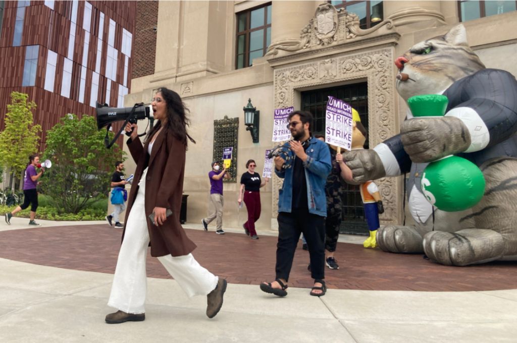 Strikers marching in a circle with Far Cat looking on