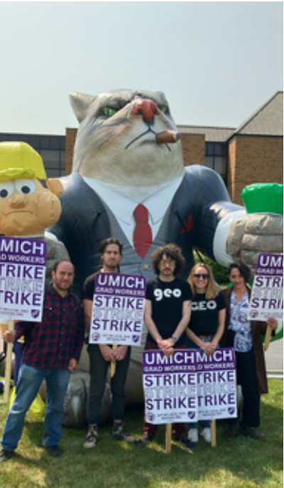 5 people holding strike signs posing in front of the Fat Cat